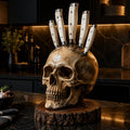 Realistic skull knife holder with white-handled kitchen knives on a dark marble kitchen counter
